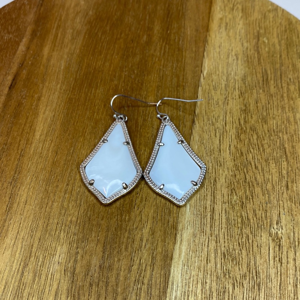 Kendra Scott white stone drop earrings.